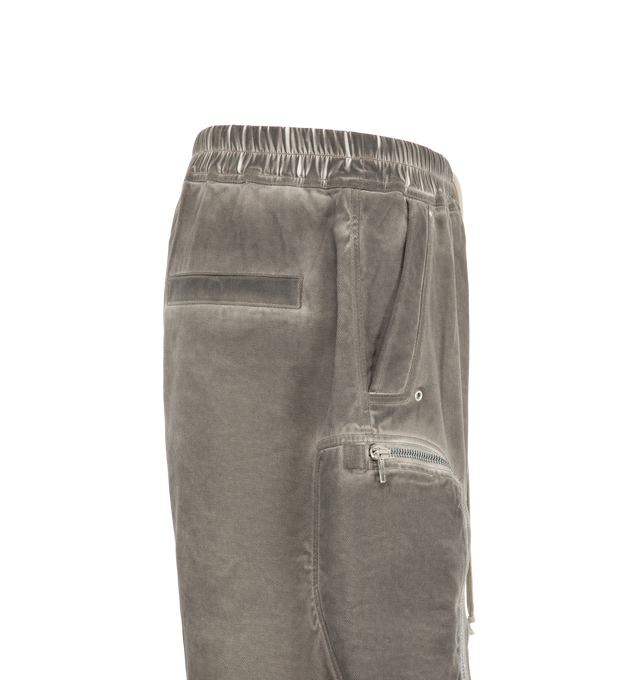 Image 3 of 3 - GREY - Rick Owens Drkshdw Men's Bauhaus Shorts are crafted from 100% cotton 13oz Lido Wash denim and feature a knee-length silhouette with a low dropped crotch. Designed with an elasticized waistband and drawstring closure, these designer shorts include side pockets, signature round Bauhaus zip pockets at the front thigh, and a webbing tab with eyelet detailing. Back jet pockets complete the utilitarian design. The medium-weight denim is overdyed and stone washed to achieve an irregular, live 
