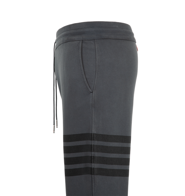 Image 3 of 3 - GREY - Thom Browne Men's Classic Loopback Sweatpants feature a pull-on waist with drawcords, and slim leg with signature stripes, logo patch and cuffed hems. Material: Cotton. 