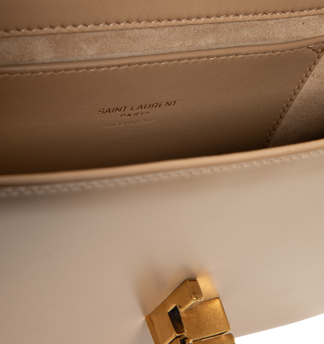 Image 3 of 3 - NEUTRAL - Saint Laurent Women's Mini Top-Handle Bag is crafted from box calfskin leather and features the iconic Cassandre sliding clasp closure, a structured top handle, a detachable and adjustable shoulder strap, bronze-tone hardware, a suede-lined interior, one card slot, and a rear flat pocket. This designer leather top-handle bag combines timeless elegance with versatile styling for day-to-evening wear. Main Material: Calfskin Leather. Lining: Suede. Hardware: Brass. Dimensions: 19.5 x 1 
