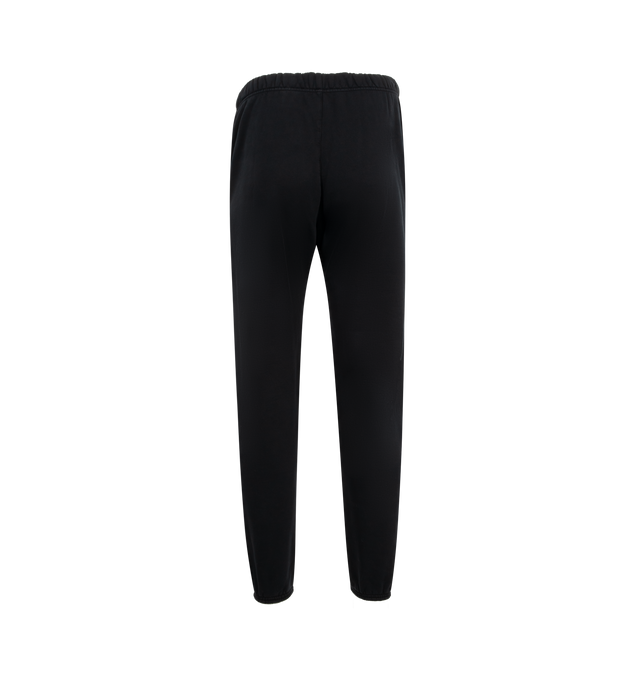 Image 2 of 3 - BLACK - Fear of God Essentials Heavy Fleece Sweatpants have an elastic drawstring waist, 3 stripe side panels, side pockets, elastic at the ankles, and a brand label. 83% cotton, 17% recycled polyester. 