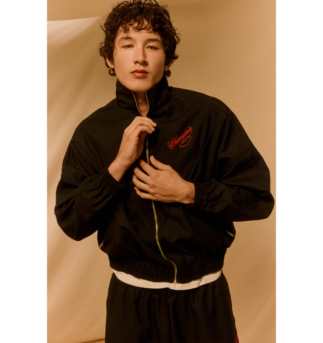 Image 2 of 5 - BLACK - WILLY CHAVARRIA Ruff Ryder Jacket featuring a nylon taffeta piped throughout, full lining, script inspired logo, stand collar, zip closure, zip pockets and elasticated trims. 100% nylon. Made in the USA. 