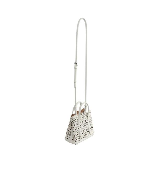 Image 2 of 3 - WHITE - Alaia Micro tote bag, crafted from calfskin leather with Vienne pattern inspired by precious lace and moucharabieh architectural openwork, snap-fastening gusseted sides that expand, galvanised silver hardware, detachable strap, hand or shoulder carry. Dimensions (cm): l 16 x h 14 x d 8. Made in italy. 