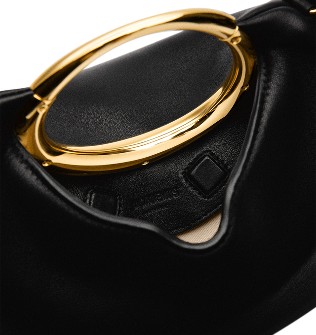Image 4 of 5 - BLACK - JACQUEMUS Le Calino Bag featuring buffed lambskin, fixed metal carry handle, adjustable and detachable shoulder strap, welt pocket with magnetic closure at face, zip closure at side, cotton twill lining and logo-engraved gold-tone hardware. H6.5" x W12.75" x D5.5". Total height: H10". 100% lambskin. Lining: 100% cotton. Made in Italy. 