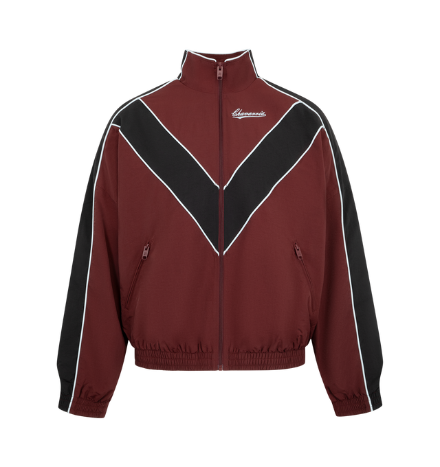 Image 1 of 3 - RED - Willy Chavarria Bad Boy Track Jacket is crafted from nylon and features a sleek, true-to-size silhouette defined by bold chevron paneling and contrast piping. Designed with a stand collar, front zip closure, two zippered pockets, stacked script logo detailing, and elasticized cuffs and hem. Main Material: 100% Nylon. Lining: Polyester. 