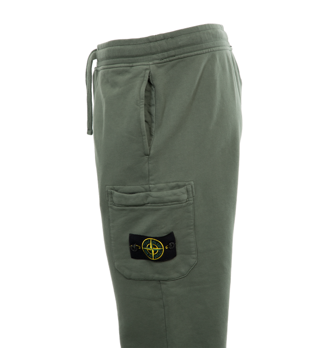 Image 3 of 4 - GREEN - STONE ISLAND Cargo Sweatpants featuring in-seam pockets, one back pocket with hidden snap fastening, patch pocket on the left leg featuring the Stone Island badge, hidden zipper closure, elasticized waist with outer drawstring, ribbed leg bottoms and zipper closure. 100% cotton. 