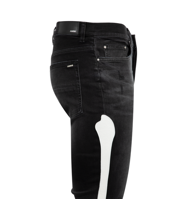 Image 4 of 4 - BLACK - AMIRI Bones Applique Distressed Jeans featuring white leather bones throughout side seams, distressed details throughout, tapered fit and ripped knees. 92% cotton, 6% elastomultiester, 2% elastane. 