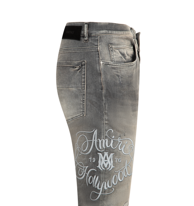 Image 3 of 3 - GREY - AMIRI Hollywood MX1 Jeans featuring used-effect stonewashed stretch cotton denim jeans with exposed ribbed suede repair, logo embroidery on the right leg, front button closure, five pockets and suede logo tag. 92% cotton, 6% elastomultiester, 2% elastane. Made in Italy. 