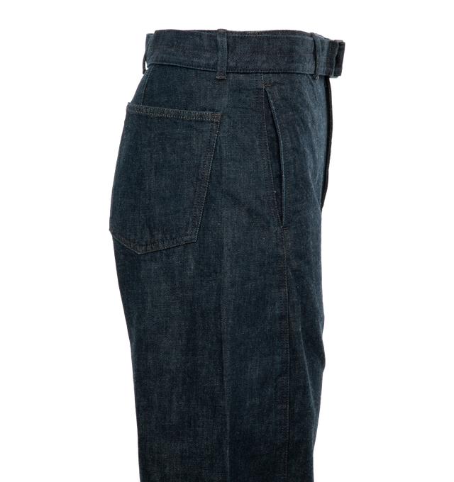 Image 3 of 4 - BLUE - LEMAIRE unisex denim pants in men's sizing. Iconic Twisted Pant crafted of a heavy denim with a visible twill weave and a deep indigo wash. Side-seams are slightly twisted giving the leg a curved shape. Featuring two side pockets, back patch pockets and contrast stitching. The fit is elongated and mid-rise and includes a matching belt to adjust the waist. 100% Cotton. 
