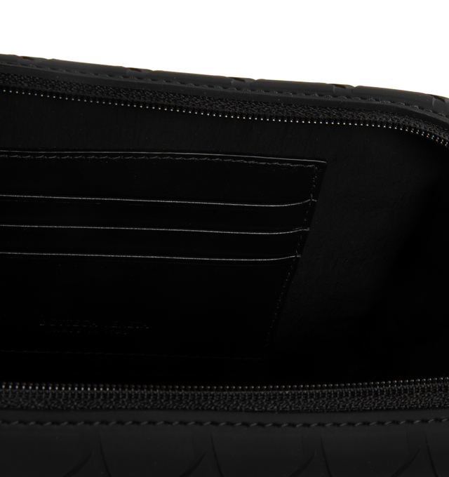 Image 3 of 3 - BLACK - BOTTEGA VENETA Tech Rubber Clutch featuring intreccio rubber silicone clutch with detachable and adjustable leather strap, three interior card slots and zippered closure. 7.3" x 4.3" x 2". Strap drop: 18.9". 100% calfskin. Made in Italy. 