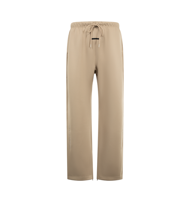 Image 1 of 4 - NEUTRAL - Fear of God ESSENTIALS Men's Classic Trackpant is crafted from heavyweight cotton-blend fleece and features a slim straight-leg silhouette with side-seam detailing and adjustable closure. Designed to provide structure and comfort, this elevated essential is finished with an encased elastic waistband, elongated drawcords, side-seam pockets, and an updated Fear of God Essentials label at the center front. Main Material: 80% Cotton, 20% Polyester Fleece, 380 GSM. Imported. 