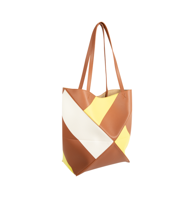 Image 2 of 3 - MULTI - Loewe Medium-Sized Puzzle Fold Graphic Tote Bag is crafted from calfskin leather and features the brand's signature geometric Puzzle Fold construction with a lightweight, foldable design. Designed with double top handles, a front logo detail, and multicolor graphic motifs created using Loewe's signature intarsia technique for a distinctive sculptural appearance. Main Material: Calfskin Leather. 