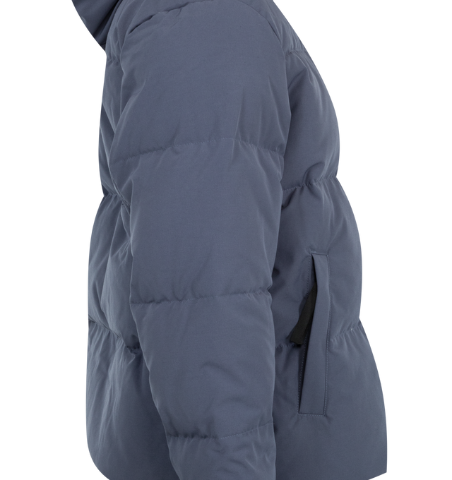 Image 4 of 4 - BLUE - Canada Goose Men's Seymour Parka is crafted from Recycled Organic Arctic Tech and features a quilt-through construction designed for protection in extreme cold-weather conditions. The parka is equipped with an adjustable snorkel hood, a tricot-lined chin guard, and a concealed snap placket over a front zip closure for enhanced coverage. Functional details include interior backpack straps for hands-free carrying, recessed rib-knit cuffs reinforced with CORDURA, two exterior zip pockets, 