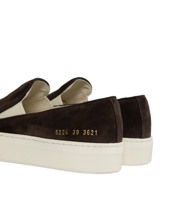 Image 3 of 5 - BROWN - Common Projects minimalist slip-on sneaker crafted from calf suede in a sleek, round-toe profile with thick rubber soles detailed at the heels with signature gold serial number stamp. Made in Italy. 
