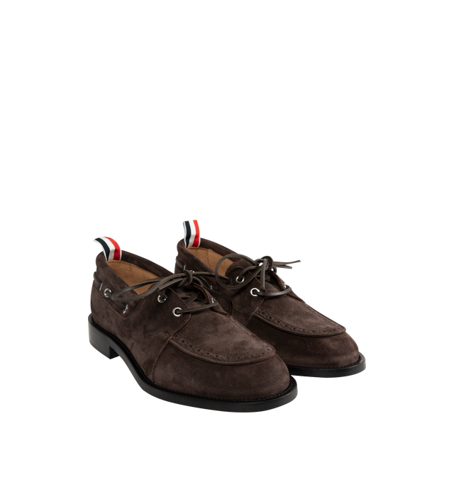 Image 2 of 4 - BROWN - Thom Browne Mens Boat Shoes are crafted from supple calf suede. Feature a lace-up closure, classic boat shoe silhouette, brogue detailing, rubber sole, and signature striped grosgrain loop tab. Main Material: Upper: 100% Calf Suede Leather; Lining: 100% Calf Leather; Sole: 100% Rubber. Made in Italy. 