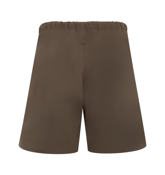 Image 2 of 3 - BROWN - FEAR OF GOD ESSENTIALS Active Trace Relaxed Short featuring a perforated lining for enhanced breathability, a voluminous, elongated silhouette, 3M Embroidered Essentials Active Trace logo divided across both legs, Essentials signature label is positioned at the center front, side pockets, leg slits and an encased elastic waistband with drawstrings. 100% polyester. 