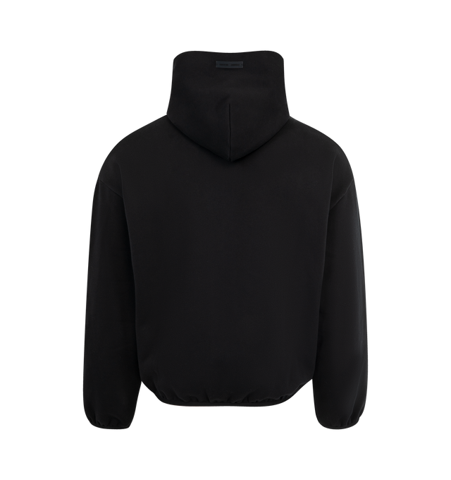 Image 2 of 3 - BLACK - FEAR OF GOD ESSENTIALS Modern Fleece Hoodie featuring 380gsm core fleece, modern fit forming wider relaxed proportions with a cropped length, rubberized labels on the center front and sleeve, double-layer hoodie, side pockets, and elasticized piping on the cuffs and waist hem. 80% cotton, 20% polyester fleece. 