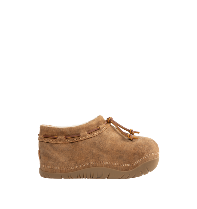 Image 1 of 4 - BROWN - UGG women's bucked clog made in soft suede with an elevated, worn-in feel and a leather whipstitch detail, signature sheepskin lining and cushy rubber platform sole. Features sugarcane EVA midsole, molded rubber outsole, woven label with UGG Logo on insole and UGG Logo embossed suede heel label. 