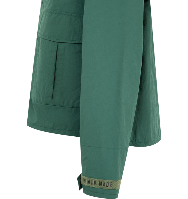 Image 3 of 4 - GREEN - HUMAN MADE Fishing Jacket featuring boxy silhouette, medium-weight nylon ripstop material, mesh lining, back vent reduces heat buildup for extra comfort, back graphic combines a polar bear patch and logo print, logo magic tape on the left chest, sleeve tabs and pocket flaps, hem drawcord with heart stoppers and packable hood stored in the collar. 100% nylon. Lining: 100% polyester. 