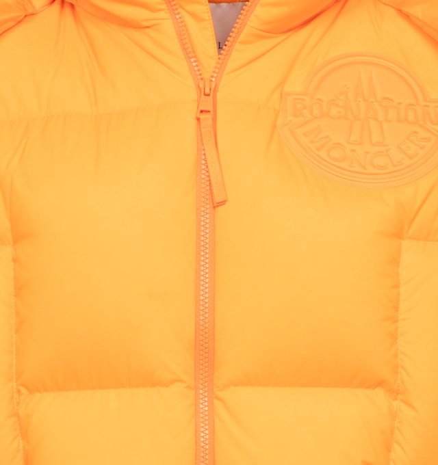 Image 4 of 5 - ORANGE - MONCLER GENIUS MONCLER X ROC NATION BY JAY-Z APUS VEST is a fluorescent-orange hue that brings standout style to this channel-quilted down vest detailed with a tonal patch bearing the logos of both labels, two-way front-zip closure, stand collar; fixed hood, chest welt pockets, front welt pockets and lined, with down fill. 100% nylon. 
