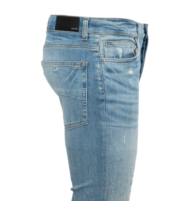 BLUE - AMIRI Crystal Shotgun Jeans featuring belt loops, five-pocket styling, button-fly, leather logo patch at back waistband and logo-engraved silver-tone hardware. 92% cotton, 6% elastomultiester, 2% elastane. Made in USA.