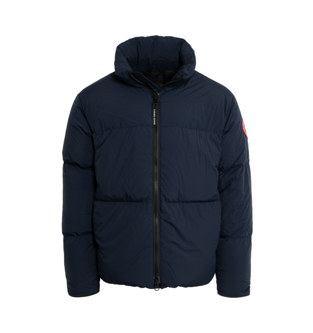 NAVY - CANADA GOOSE Lawrence Water Repellent 750 Fill Power Down Puffer Jacket featuring two-way front-zip closure, stand collar, inset ribbed cuffs, hidden side-zip pockets, interior zip pocket, interior mesh drop-in pockets, interior shoulder straps for hands-free carry, reflective details enhance visibility in low light or at night, water-repellent and lined with 750-fill-power down fill. 100% recycled nylon. Made in Canada.