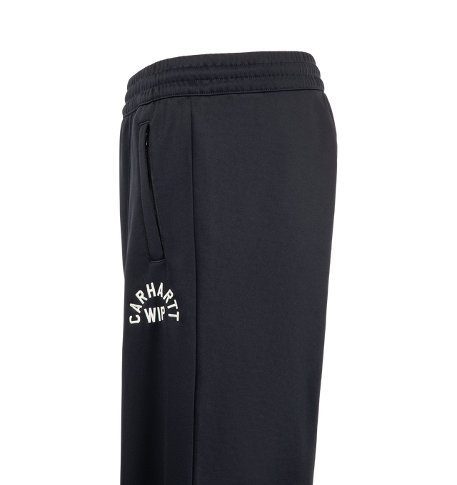 Image 3 of 4 - NAVY - Carhartt WIP Men's Bolon Sweat Pant is crafted from midweight polycotton interlock and features a loose fit, adjustable elasticated waistband, embroidered graphic lettering, and zip openings at the leg hems. Designed for everyday comfort and utility, it is finished with zip welt pockets at the sides and a zip back pocket. Main Material: 64% Polyester, 36% Cotton Interlock.  