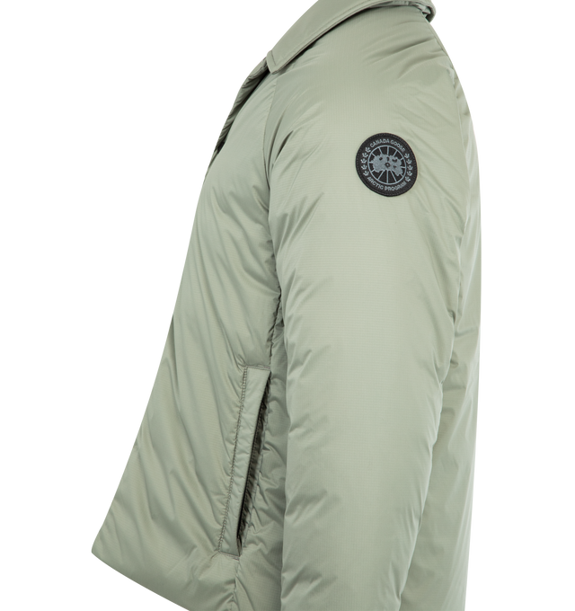 Image 3 of 3 - GREEN - CANADA GOOSE Lodge Coach Jacket featuring a pointed collar, packable into interior zip pocket, snap front closure, two exterior zippered pockets and two interior pockets: one drop-in pocket, one zippered security pocket. 100% nylon. Made in Canada. 
