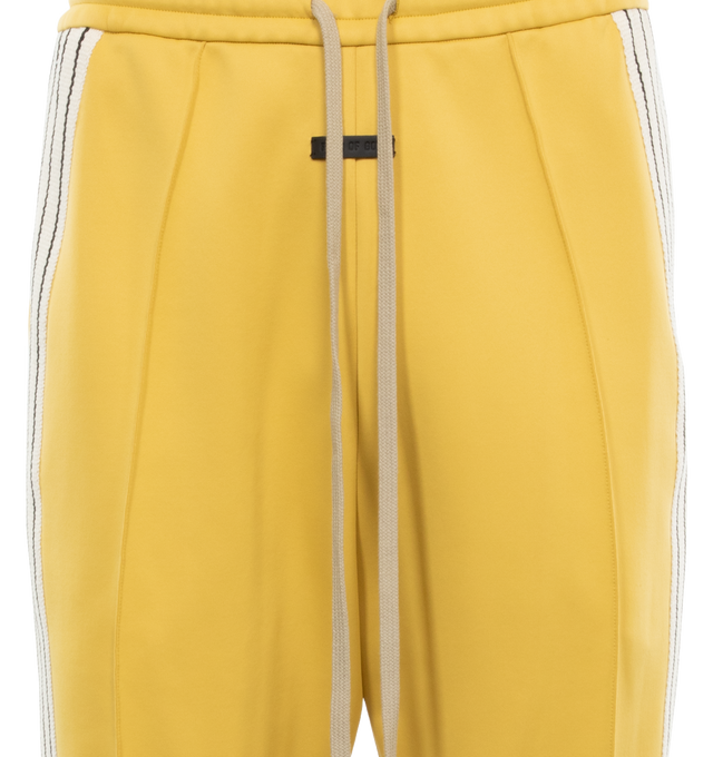 Image 4 of 4 - YELLOW - FEAR OF GOD Stripe Relaxed Sweatpant featuring a relaxed fit with a pintuck stitch to shape the leg and a sports-inspired canvas side stripe, pockets, encased elastic waistband, elongated drawstrings and Fear of God leather label at the center front. 60% nylon, 40% cotton. 