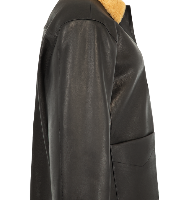 Image 3 of 3 - BLACK - Khaite Women's Wilson Caban Jacket is crafted from robust grained nappa lambskin and features a relaxed caban silhouette inspired by classic workwear. Designed with a curly lambskin shearling collar, button-front closure, graphic stitching, back yoke, quilted lining, duck down insulation, and oversized patch pockets for added functionality. Main Material: 100% Lambskin. Made in Italy. 