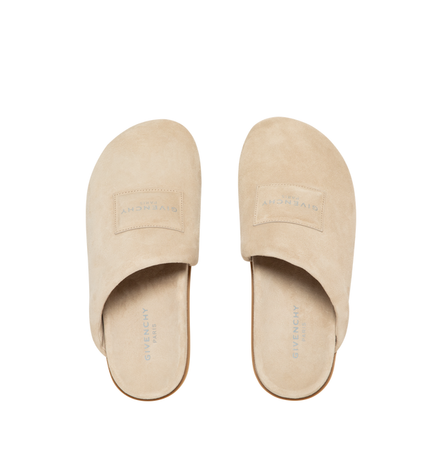 Image 5 of 5 - NEUTRAL - Givenchy Puffy Mules in Suede are crafted from supple calfskin suede and feature the house's signature Puffy silhouette with an asymmetric, slip-on design. Designed with a tonal padded label accented by a silvery Givenchy Paris logo, a branded leather insole, and a raised Givenchy signature beneath the sole, the mules combine comfort with a refined contemporary aesthetic. Main Material: 100% Calfskin Leather. Lining: 100% Calfskin Leather. Made in Italy. 