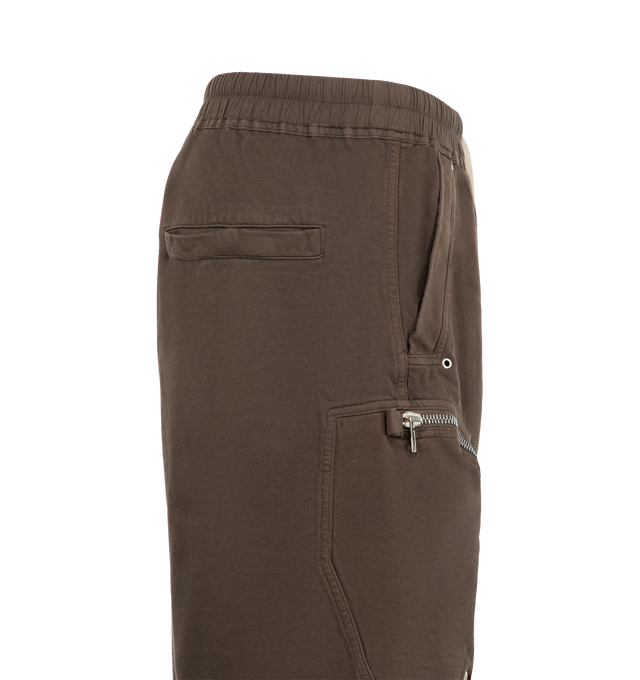 Image 3 of 3 - BROWN - Rick Owens DRKSHDW Men's Bauhaus Shorts are crafted from heavyweight garment-dyed cotton jersey with a soft brushed finish. Cut to a knee-length silhouette with a low dropped crotch, they feature an elasticized drawstring waistband, side pockets, signature Bauhaus zip pockets at the thighs, and back jet pockets. Webbing tab and eyelet details complete the utilitarian design. Main Material: 100% Cotton. 