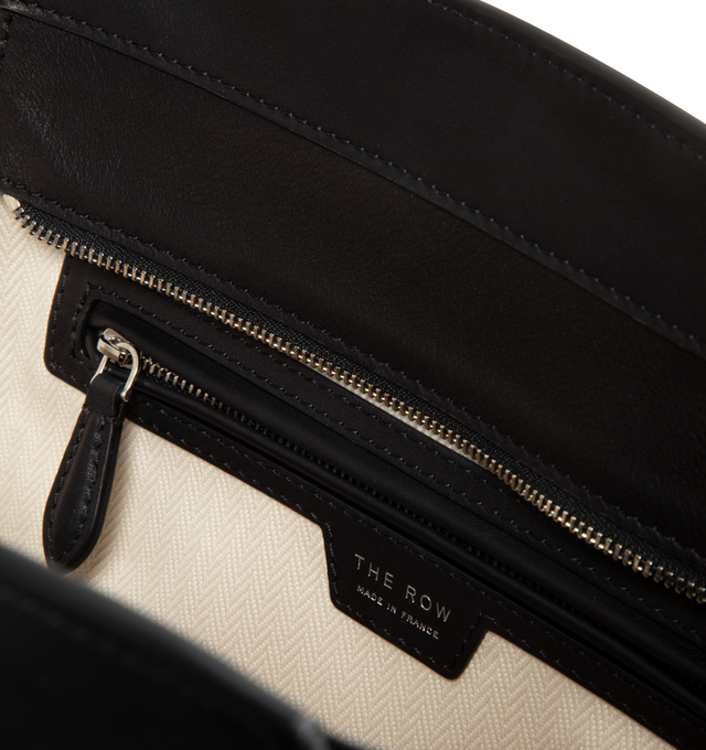 Image 3 of 3 - BLACK - THE ROW Marlo 12 Bag in Leather featuring softly structured tote bag in polished saddle leather with tubular handles, gusseted side panels and top zipper closure. Untreated and drum-dyed, the leather develops character with time and use. 12 x 15.5 x 8.28 in. Handle: 6.89 in. drop. 100% calfskin leather. Lined in 100% cotton. Made in France. 