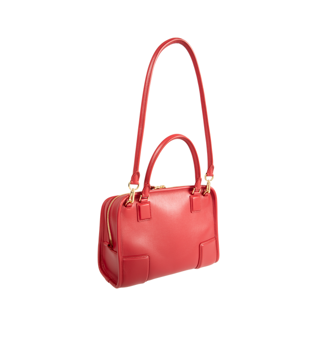 Image 4 of 5 - RED - Loewe Small Amazona 180 Bag in leather features a relaxed silhouette anchored by a single toron top handle, designed to be carried open, while a concealed closure secures the main compartment, three carry options: short handle, removable shoulder strap and crossbody, zip closure with two leather zip pullers, two compartments, main compartment closed with magnetic closure, internal flat pocket, left side d-ring for customization, nappa lambskin lining, and embossed double L branding. Lea 
