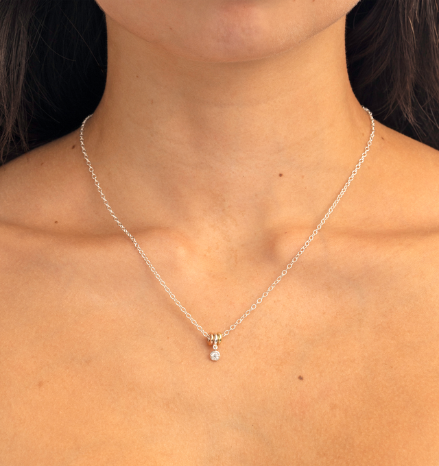Image 2 of 2 - GOLD - Spinelli Kilcollin Vesta Round MX WD Necklace features a trio of full-round annulets crafted from .925 sterling silver, 18k rose gold, and 18k yellow gold, suspending a bezel-set round white diamond drop charm. Designed with freely moving mixed-metal annulets that glide along the chain, this signature necklace balances sculptural form with everyday elegance. Main Material: .925 Sterling Silver, 18k Rose Gold, 18k Yellow Gold. Stone: Round White Diamond, Approx. 0.09 cttw. Details: Thre 