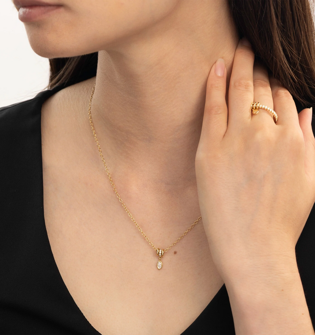 Image 2 of 2 - GOLD - Spinelli Kilcollin Vesta Marquise YG WD Pav Necklace is crafted from 18k yellow gold and features a trio of full-round annulets adorned with pav-set white diamonds that move freely along the chain. Suspended from the annulets is a marquise-cut natural white diamond drop charm, creating a refined balance of movement and brilliance. Handcrafted in Los Angeles, this signature design blends Spinelli Kilcollin's sculptural aesthetic with everyday elegance. Main Material: 18k Yellow Gold. St 