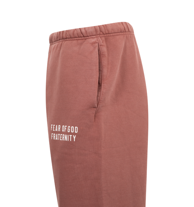 Image 3 of 3 - RED - Fear of God Essentials Elastic Waist Fleece Sweatpants have a drawstring elastic waist, side pockets, a brand label, and elastic at the ankles. 83% cotton, 17% recycled polyester.  