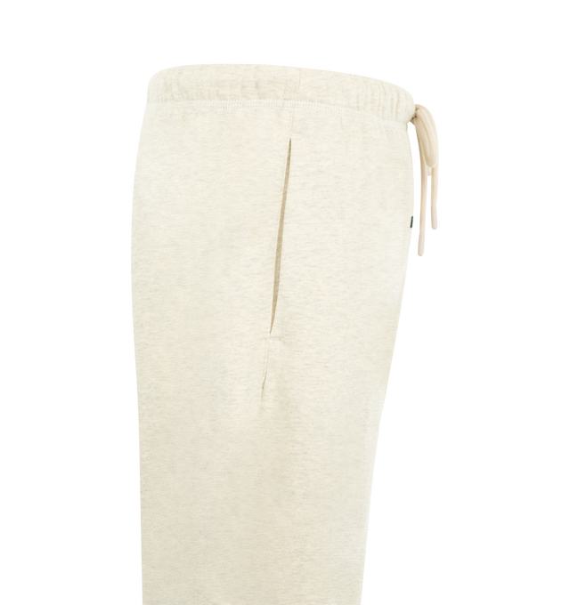 Image 3 of 3 - NEUTRAL - Fear of God Essentials Mens Flare Sweatpants are crafted from heavyweight 390 GSM cotton fleece. Feature a relaxed flared-leg fit, elasticized waistband with bungee drawcord, side-seam pockets, pigment-dyed finish, and an Essentials signature label. Main Material: 100% Cotton. 