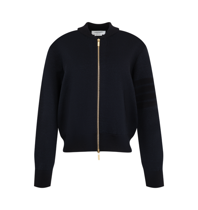 Image 1 of 3 - NAVY - Thom Browne Women's Ottoman Milano Stitch 4-Bar Bomber Jacket is crafted from wool and features the brands signature 4-bar detailing rendered in a raised ottoman-stitch construction along the sleeve. Designed with a refined bomber silhouette, the jacket is finished with a two-way zip closure, rib-knit bomber collar, cuffs, and hem, and welt hand pockets with rib-knit trim. Thom Brownes signature striped grosgrain loop tab completes the design. Main Material: Wool. Made in Italy. 