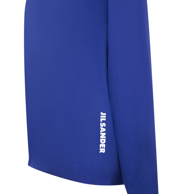 Image 3 of 3 - BLUE - Jil Sander Men's Cotton Terry Crew-Neck Sweatshirt is crafted from lightweight cotton terry and features a relaxed-fit silhouette with slightly dropped shoulders. Designed with a ribbed crew neck, hem and cuffs, and a vertical printed Jil Sander logo that reflects the brand's clean, modern aesthetic. Main Material: 100% Cotton. Made in Italy. 