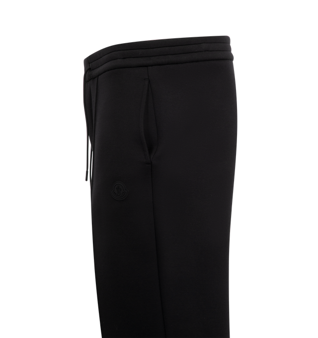 Image 3 of 3 - BLACK - Moncler Logo Cotton and Neoprene Sweatpants have an elastic drawstring waistband, front pleats, side pockets, a silicone logo patch, and a snap button back pocket. 55% cotton, 45% polyester. Made in Turkey.  