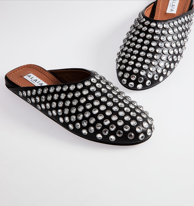 BLACK - ALAIA Crystal Stud Leather Flat Mules featuring flat heel, round toe and slide style. Leather. Rubber outsole. Made in Italy.