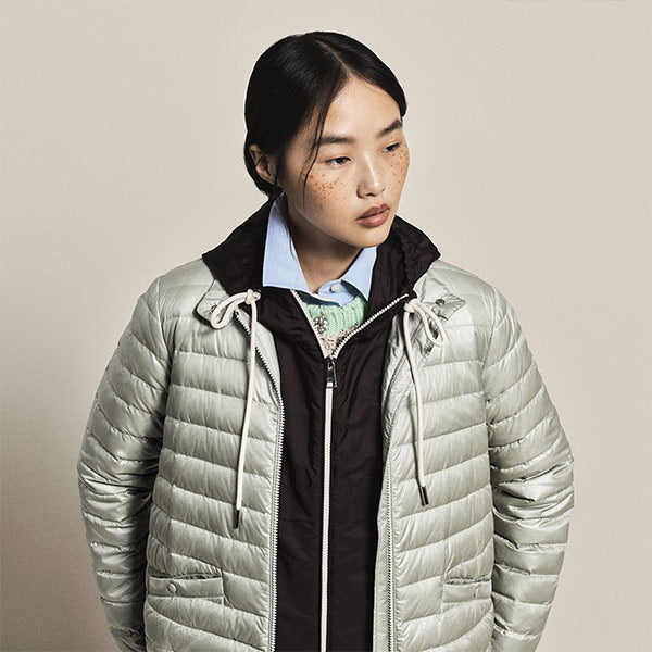 Woman wearing a light gray puffer jacket by Moncler