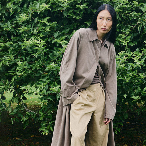 Woman wearing brown car coat and trousers by The Row