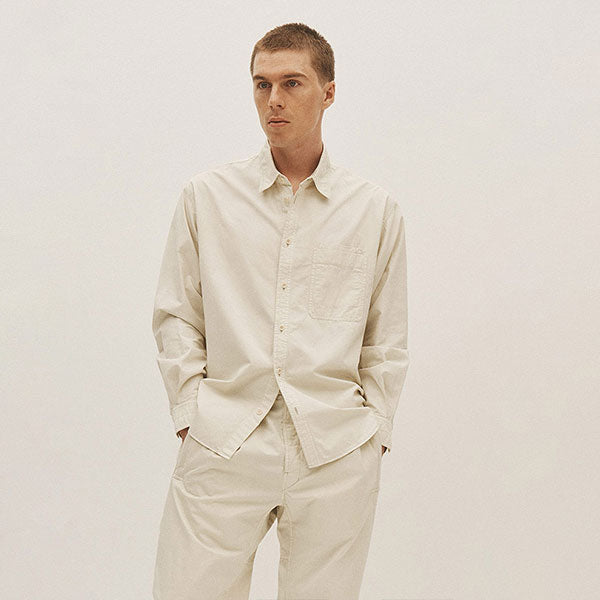 Man wearing off-white color button-up shirt and drawstring pants by LeMaire