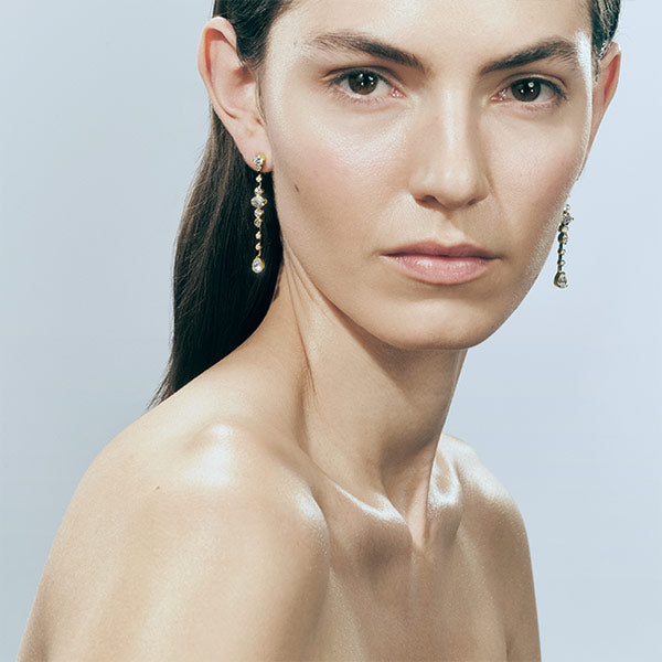 Woman wearing SOPHIE BILLE BRAHE Starry Earrings in yellow gold and white diamonds