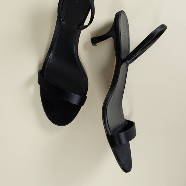 The Row black slingback heeled sandals with a single wide strap across the instep