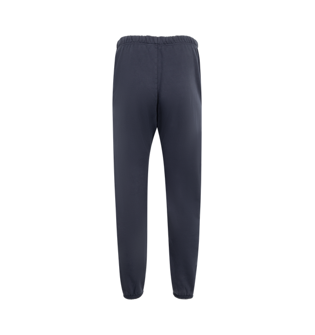 Image 2 of 3 - NAVY - Fear of God Essentials Heavy Fleece Sweatpants have an elastic drawstring waist, 3 stripe side panels, side pockets, elastic at the ankles, and a brand label. 83% cotton, 17% recycled polyester. 