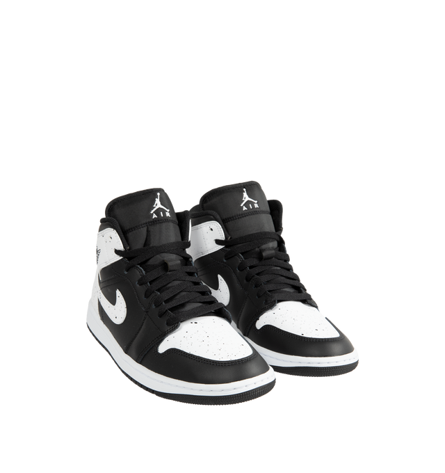 Image 2 of 5 - MULTI - Jordan Men's Air Jordan 1 Mid SE Sneakers feature a black and white upper crafted from genuine leather and textile. The mid-top silhouette is accented with a Wings logo at the collar and a Jumpman logo on the tongue, while an encapsulated Nike Air-Sole unit provides lightweight cushioning. Upper: Genuine Leather and Textile. Sole: Rubber.  