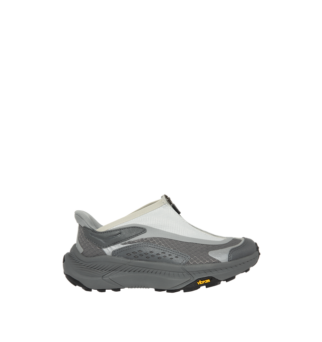 Image 1 of 5 - GREY - Hoka Project Transport Sneakers feature a shrouded ripstop upper with textured synthetic overlays for lightweight durability and a sleek, modern look. Designed for everyday wear, these performance sneakers include a quick-lace system with a zippered shroud, reflective details, signature HOKA cushioning, and a Vibram Ecostep outsole for reliable traction and lasting comfort. Main Material: Ripstop Textile and Synthetic. Sole: Vibram Rubber. Made in Vietnam. 
