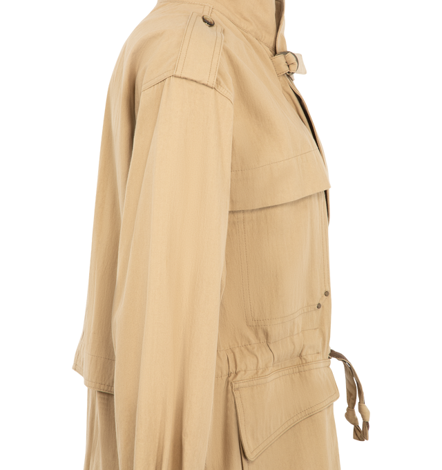 Image 3 of 4 - NEUTRAL - Isabel Marant Womens Adelys Jacket is crafted from textured cotton gabardine. Features a cropped trench silhouette, concealed front zip closure, double lapel collar with tab and metal ring, dropped shoulders with button tabs, buttoned cuffs, gusseted flap pockets, patch chest pockets, adjustable tie belt at the waist, back storm flap, and tonal topstitching. Main Material: 74% Cotton, 26% Polyamide. Made in Morocco. 